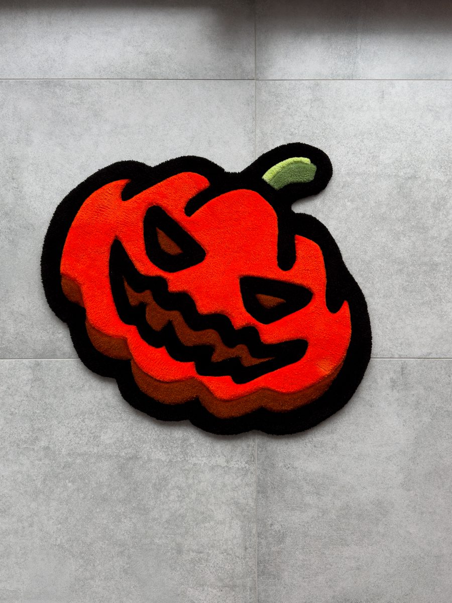 Ręcznie tuftowany dywan w kształcie dyni na Halloween, powieszony na kafelkowej ścianie