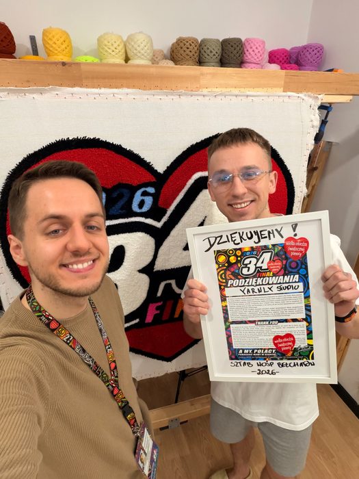 Zespół Yarnly Studio z dywanem w kształcie serca i podziękowaniem od sztabu WOŚP